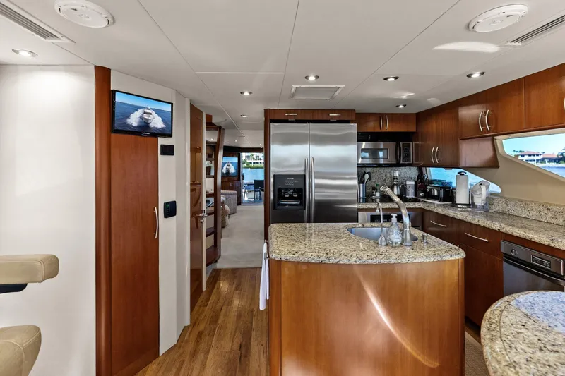  Yacht Photos Pics Luxurious Lazzara yacht kitchen with granite countertops, stainless steel appliances, and wooden cabinetry.