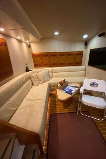  Yacht Photos Pics Interior of 2004 Cabo 45 Express Los Suenos Edition yacht with beige seating and wooden accents.