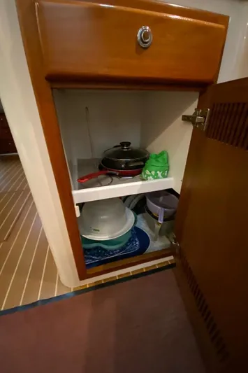  Yacht Photos Pics Cabinet interior with cookware and dishes on a 2004 Cabo 45 Express Los Suenos Edition.