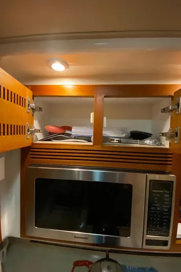  Yacht Photos Pics 2004 Cabo 45 Express Los Suenos Edition kitchen with microwave and open cabinet.