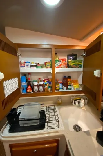  Yacht Photos Pics 2004 Cabo 45 Express Los Suenos Edition kitchen with stocked cabinets and sink.