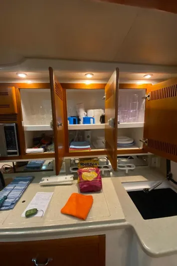  Yacht Photos Pics 2004 Cabo 45 Express Los Suenos Edition kitchen with open cabinets and countertop items.