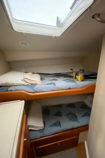  Yacht Photos Pics 2004 Cabo 45 Express Los Suenos Edition cabin with bunk beds and fishing rods.