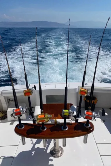  Yacht Photos Pics 2004 Cabo 45 Express Los Suenos Edition with fishing rods on open sea.