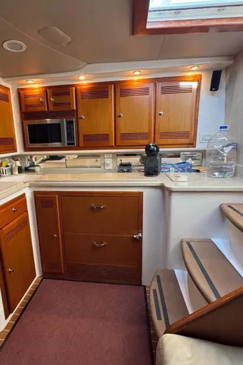  Yacht Photos Pics 2004 Cabo 45 Express Los Suenos Edition yacht kitchen with wooden cabinets and modern appliances.