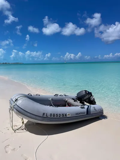  Yacht Photos Pics Inflatable boat on tropical beach with turquoise water, under a clear blue sky.