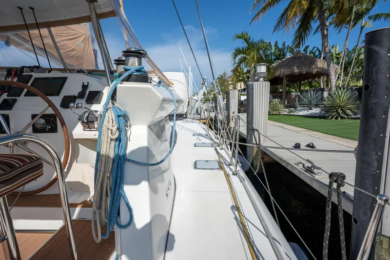  Yacht Photos Pics 2009 Lagoon 420 yacht docked, showcasing deck and steering wheel, with tropical backdrop.
