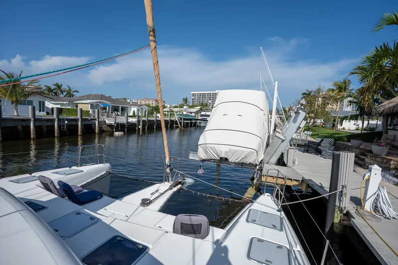  Yacht Photos Pics 2009 Lagoon 420 yacht docked in a sunny marina, surrounded by palm trees and waterfront homes.