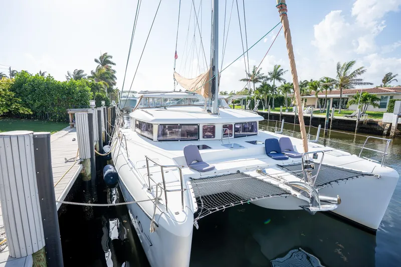  Yacht Photos Pics 2009 Lagoon 420 catamaran docked, featuring spacious deck and netting, surrounded by tropical scenery.