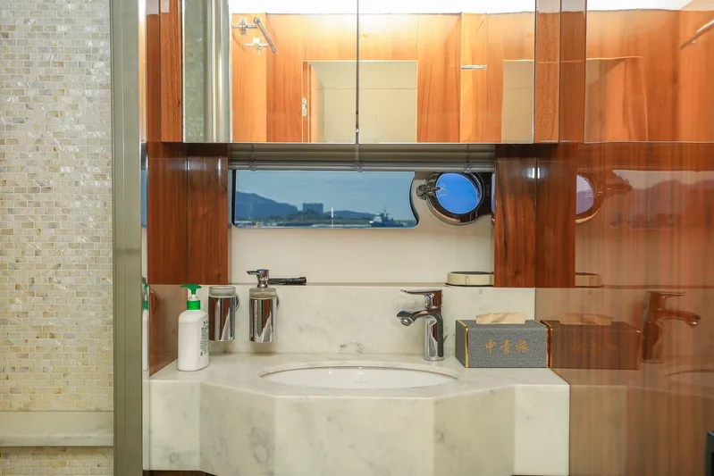  Yacht Photos Pics Luxurious bathroom interior of 2015 Sunseeker 75 Yacht with marble sink and wooden cabinetry.