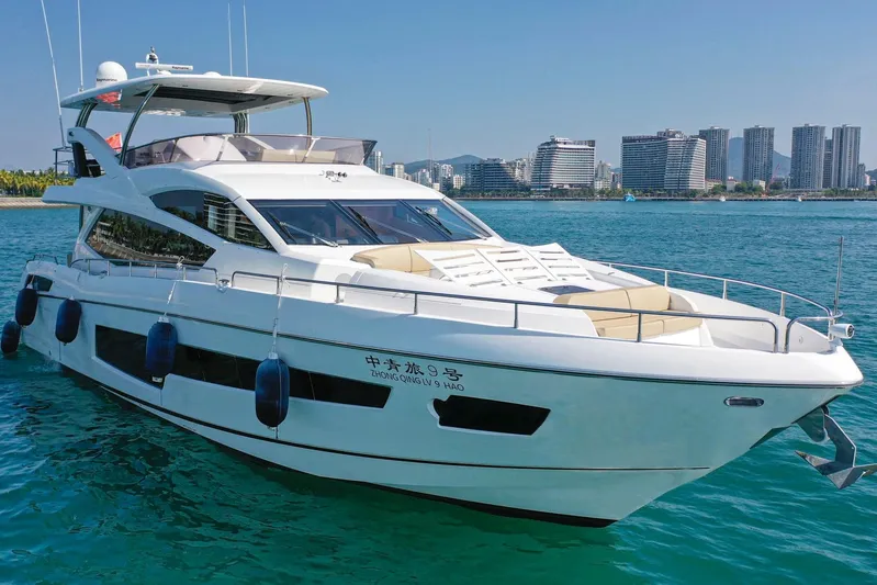  Yacht Photos Pics 2015 Sunseeker 75 Yacht cruising near a city skyline on a sunny day.