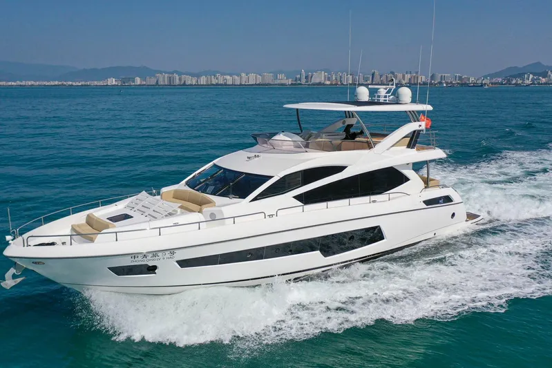  Yacht Photos Pics 2015 Sunseeker 75 Yacht cruising on blue ocean with city skyline in background.