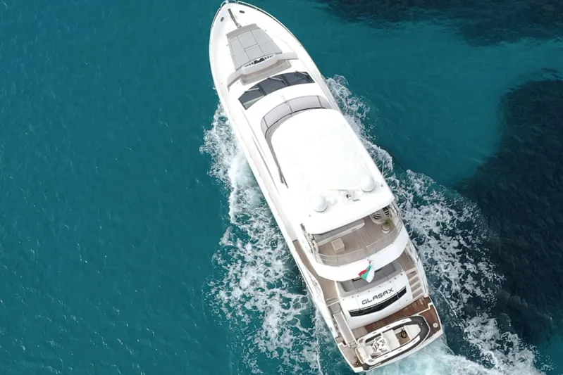 Glasax Yacht Photos Pics Aerial view of 2016 Sunseeker 75 Yacht cruising in clear blue waters.