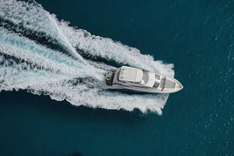 Glasax Yacht Photos Pics Aerial view of 2016 Sunseeker 75 Yacht cruising on open blue sea.