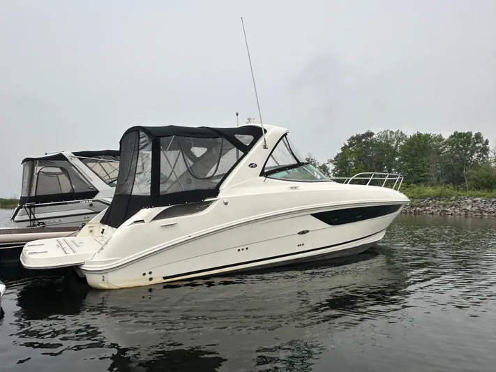  Yacht Photos Pics 2017 Sea Ray Sundancer 310 yacht docked on calm water, side view.
