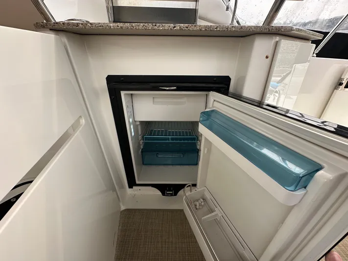  Yacht Photos Pics Open mini fridge inside 2017 Sea Ray Sundancer 310 yacht, featuring granite countertop.