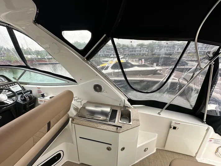  Yacht Photos Pics Interior of a 2017 Sea Ray Sundancer 310 boat with helm and kitchenette.