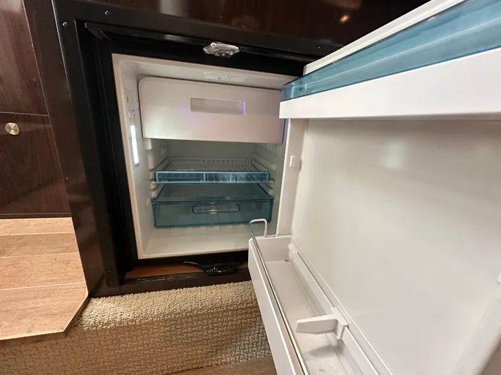  Yacht Photos Pics Open refrigerator inside 2017 Sea Ray Sundancer 310 yacht, showcasing interior storage compartments.