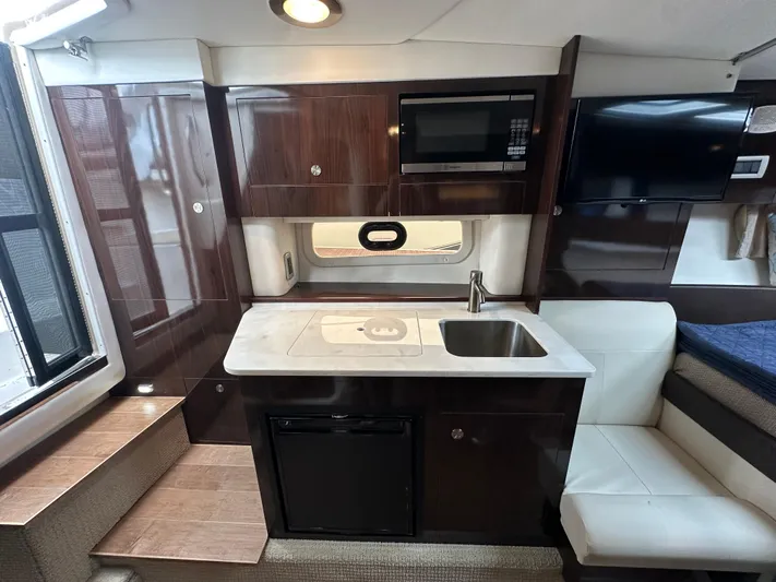  Yacht Photos Pics 2017 Sea Ray Sundancer 310 interior with kitchenette, sink, microwave, and seating area.