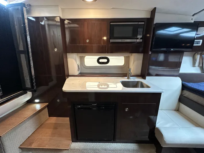  Yacht Photos Pics 2017 Sea Ray Sundancer 310 interior with kitchenette, microwave, sink, and seating area.