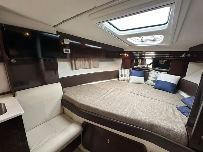  Yacht Photos Pics 2017 Sea Ray Sundancer 310 cabin interior with bed, skylight, and TV.