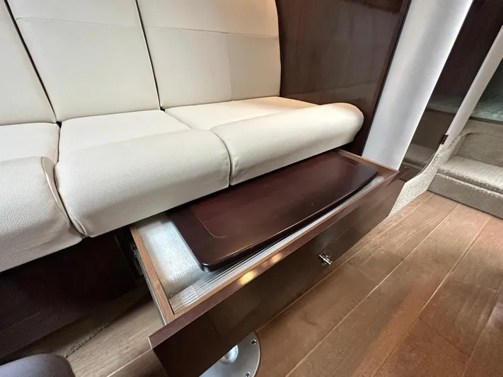  Yacht Photos Pics 2017 Sea Ray Sundancer 310 interior with beige seating and wooden storage drawer.