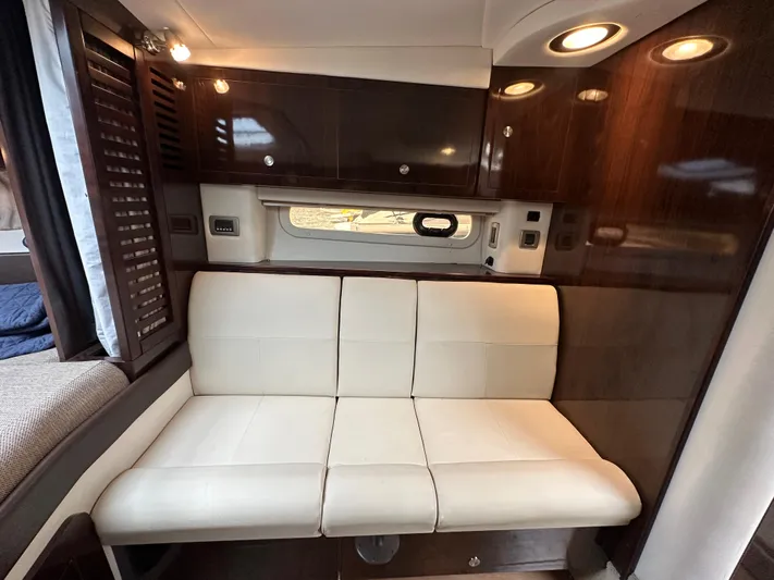  Yacht Photos Pics Luxurious interior of 2017 Sea Ray Sundancer 310 with cream leather seating and wooden cabinetry.