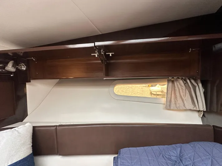  Yacht Photos Pics 2017 Sea Ray Sundancer 310 cabin interior with window, brown seating, and storage.