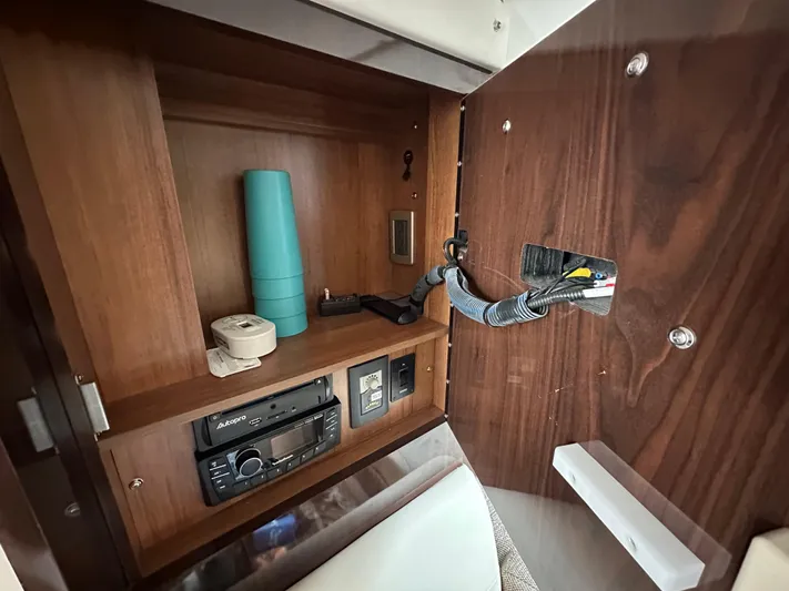  Yacht Photos Pics Interior cabinet of 2017 Sea Ray Sundancer 310 with electronics and storage items.