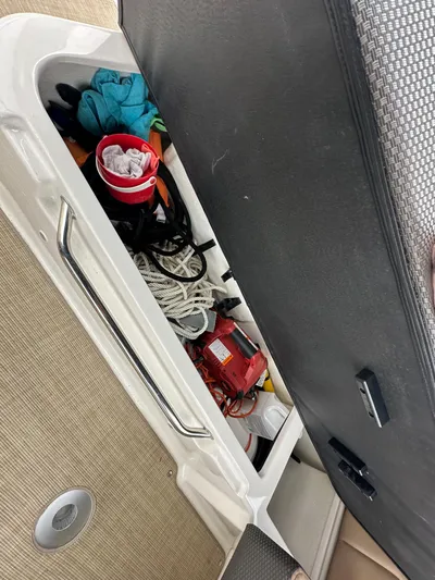  Yacht Photos Pics Storage compartment on a 2017 Sea Ray Sundancer 310 boat with various items.