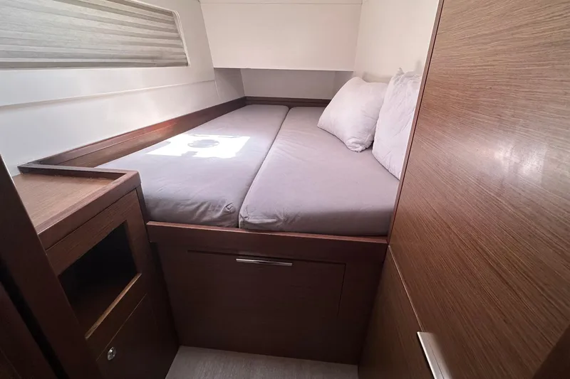  Yacht Photos Pics Cozy cabin interior of 2018 Lagoon 40 catamaran with wooden finish and comfortable bedding.