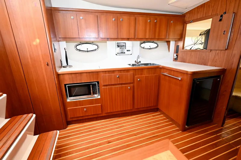 Amejaie II Yacht Photos Pics Luxurious 2000 Tiara Yachts 3500 Express interior kitchen with wood cabinetry and modern appliances.