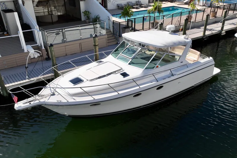 Amejaie II Yacht Photos Pics 2000 Tiara Yachts 3500 Express docked near waterfront property with pool.