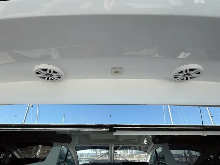 Emilia Yacht Photos Pics 2022 Cruisers Yachts 54 Cantius, exterior speakers and ceiling detail, marina background.