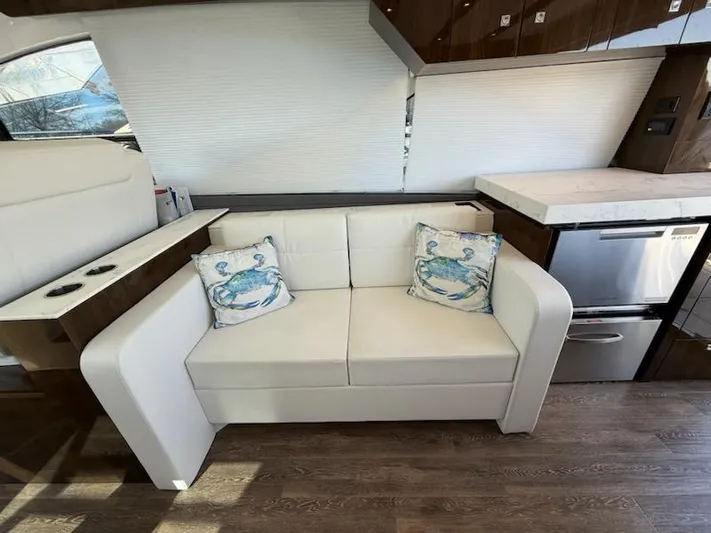Emilia Yacht Photos Pics Luxurious interior of 2022 Cruisers Yachts 54 Cantius with white sofa and nautical pillows.