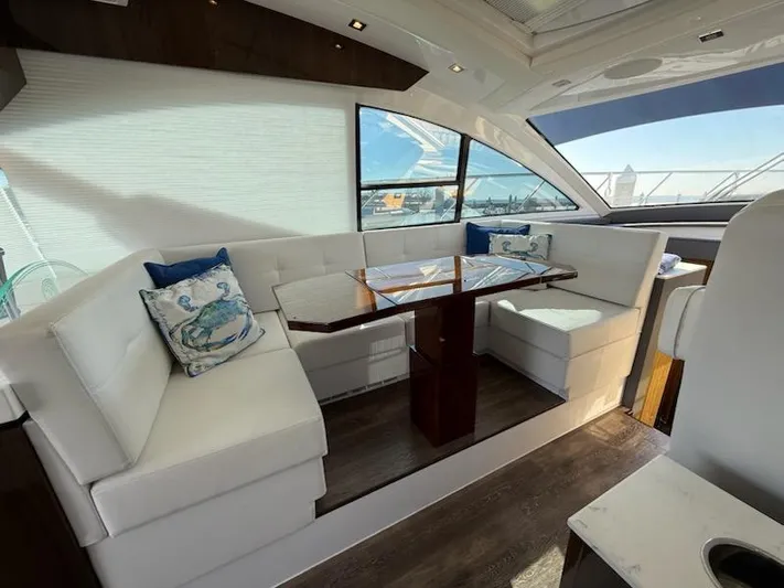 Emilia Yacht Photos Pics Luxurious interior of 2022 Cruisers Yachts 54 Cantius with elegant seating and table.