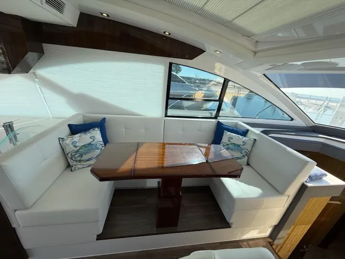 Emilia Yacht Photos Pics Luxurious 2022 Cruisers Yachts 54 Cantius interior with elegant seating and wooden table.