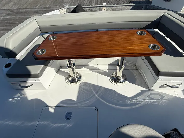 Emilia Yacht Photos Pics 2022 Cruisers Yachts 54 Cantius deck with wooden table and cushioned seating.