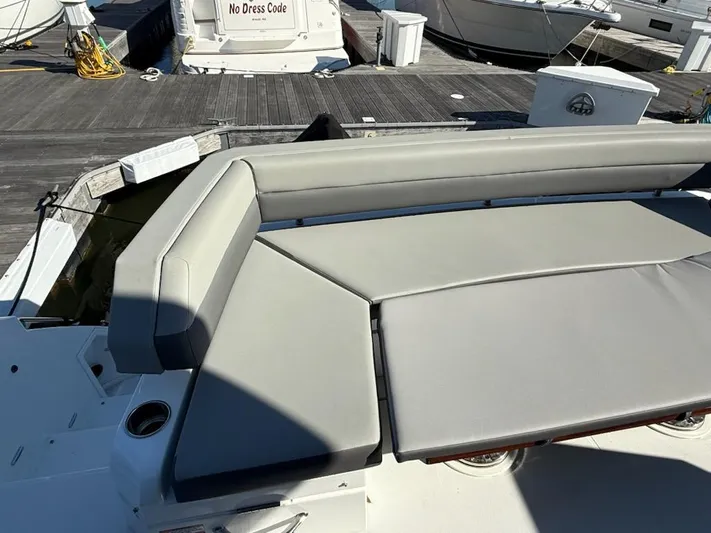 Emilia Yacht Photos Pics 2022 Cruisers Yachts 54 Cantius with gray seating on a sunny dock.