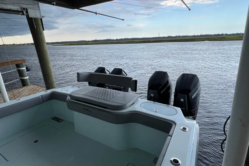  Yacht Photos Pics 2025 Front Runner 37 Catamaran docked, featuring triple outboard engines on a serene waterway.