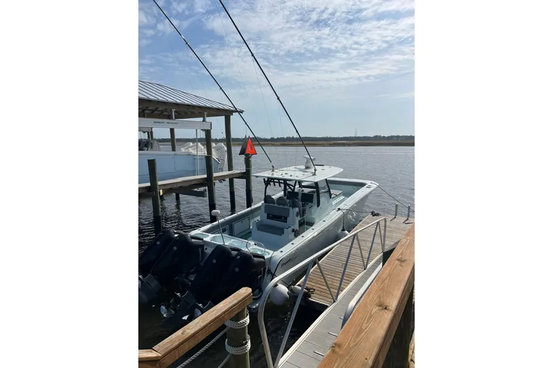  Yacht Photos Pics 2025 Front Runner 37 Catamaran docked by a wooden pier under a clear sky.