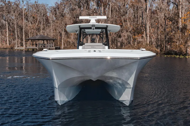  Yacht Photos Pics 2025 Front Runner 37 Catamaran on a serene lake with wooded backdrop.