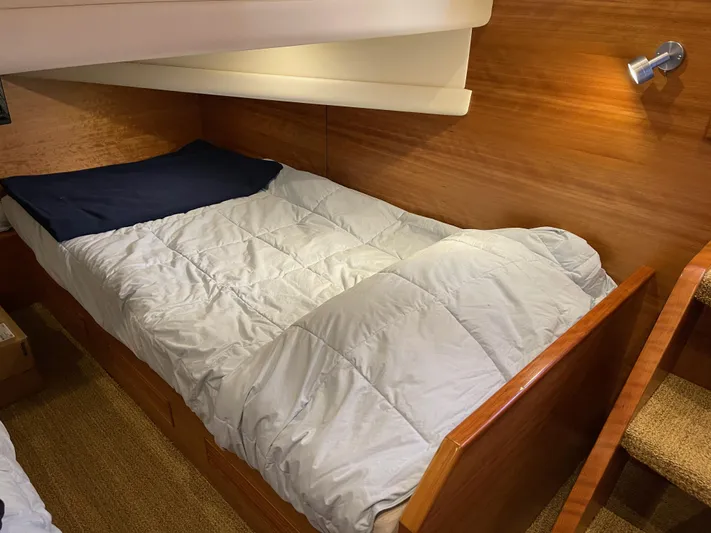  Yacht Photos Pics Cozy cabin bed in 2012 Coastal Craft 56 yacht, featuring wooden interior and soft lighting.