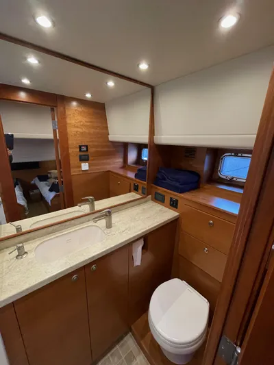  Yacht Photos Pics Luxurious bathroom in 2012 Coastal Craft 56 yacht, featuring modern fixtures and wooden cabinetry.