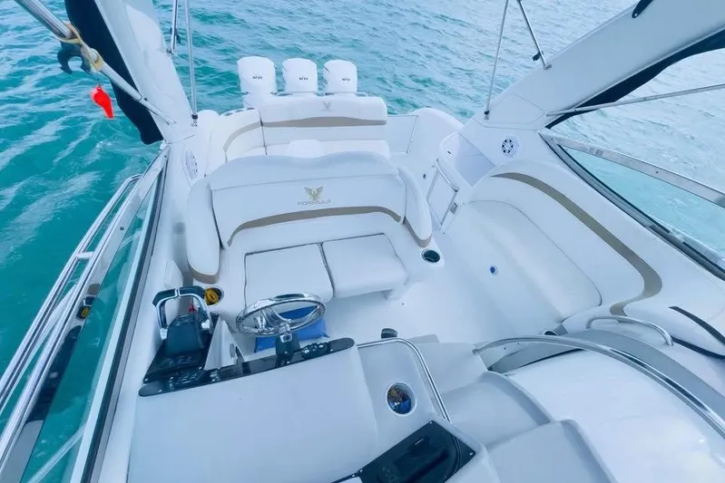  Yacht Photos Pics 2003 Formula 34 Performance Cruiser interior with white seating and helm, on blue water.