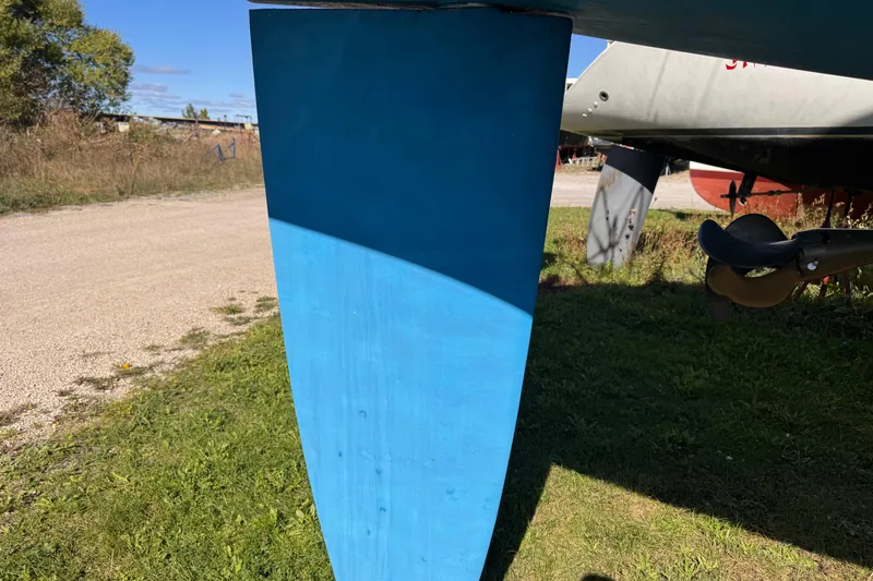 Still In The Moment Yacht Photos Pics Blue keel of a 2007 Beneteau 423 sailboat on grassy ground.