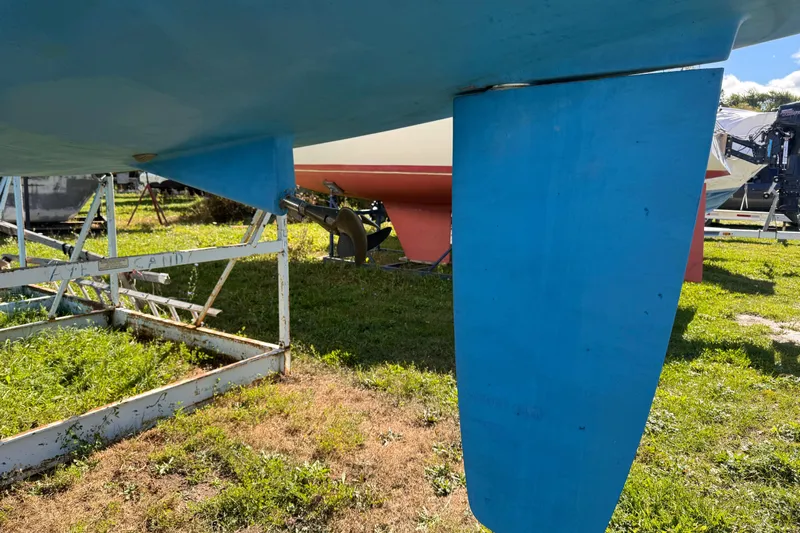 Still In The Moment Yacht Photos Pics Blue keel of a 2007 Beneteau 423 sailboat on a metal stand.