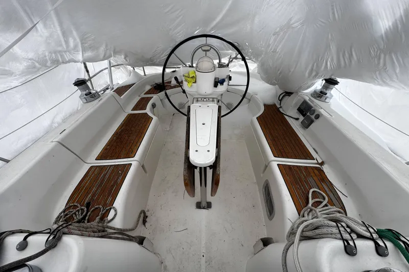 Still In The Moment Yacht Photos Pics Cockpit of 2007 Beneteau 423 sailboat with wooden seating and steering wheel.