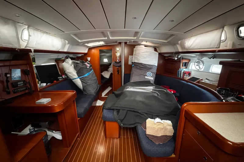 Still In The Moment Yacht Photos Pics Interior of a 2007 Beneteau 423 sailboat with wooden furnishings and seating.