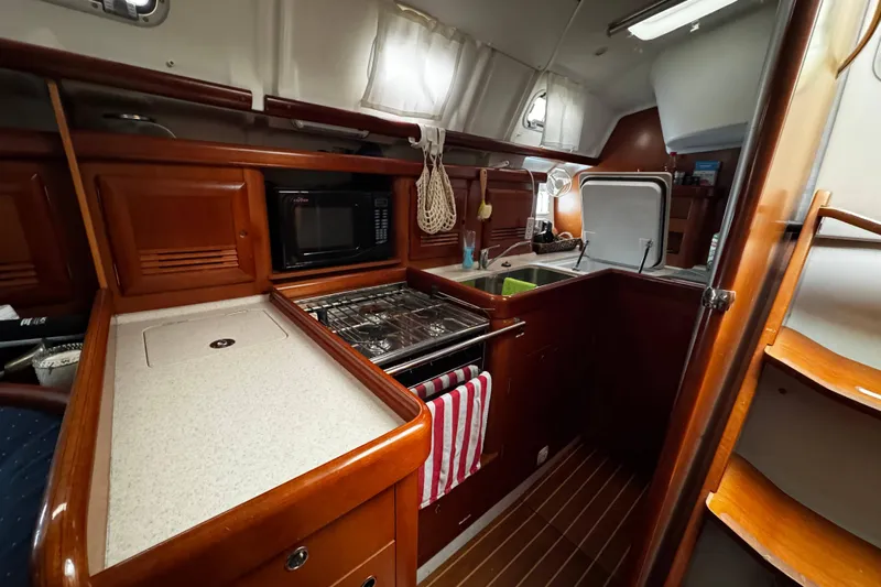 Still In The Moment Yacht Photos Pics Interior view of 2007 Beneteau 423 yacht kitchen with stove, microwave, and sink.
